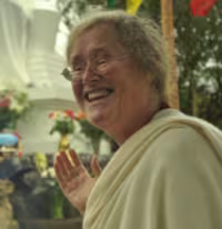 Lama Shenpen pointing at stupa